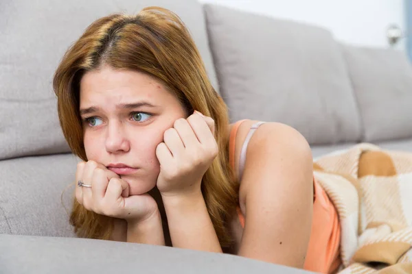 Smutna kobieta na przytulnej kanapie w domu — Zdjęcie stockowe