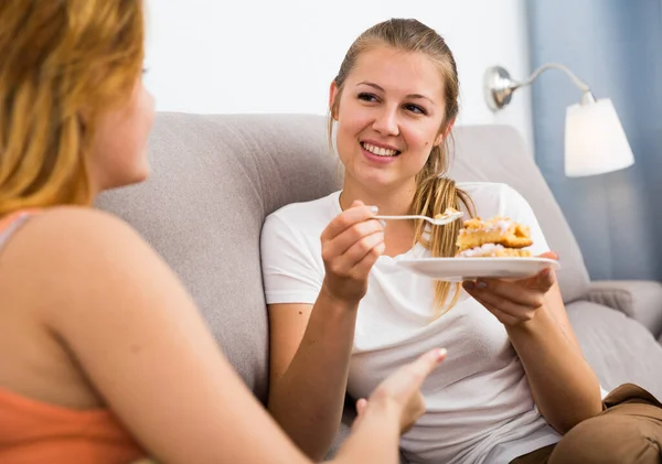 Vrolijke vrouwen praten en eten taart — Stockfoto