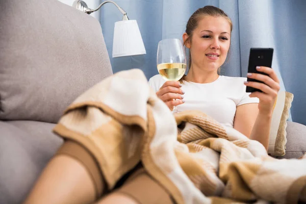 Junge Frau mit modernem Handy und Wein — Stockfoto