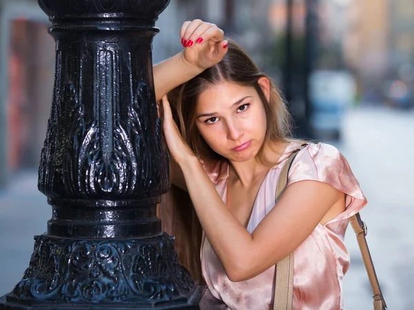 Unglückliche junge Frau steht in der Altstadt — Stockfoto