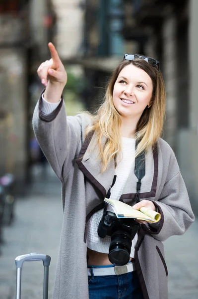 Utazó lány keresi az irányt egy szórólap segítségével a városban — Stock Fotó