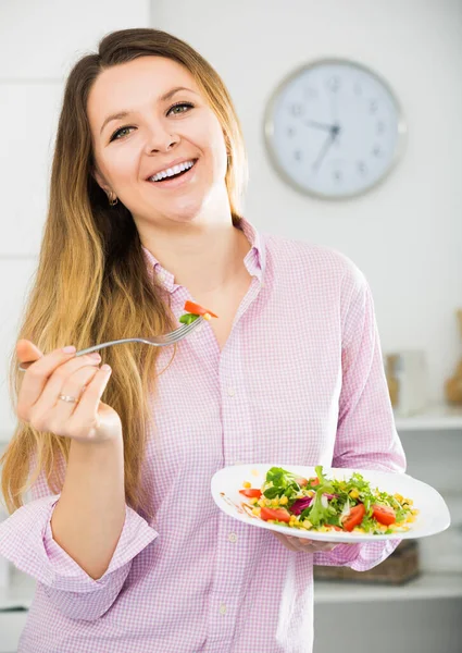 Cheerfull joven hembra comiendo ensalada verde — Foto de Stock