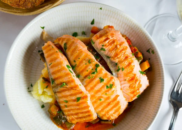 Sabroso filete de salmón a la parrilla en salsa con pimienta y limón en el plato — Foto de Stock