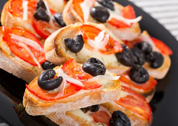 Sanduíches saborosos com queijo, tomate e azeitonas no prato — Fotografia de Stock