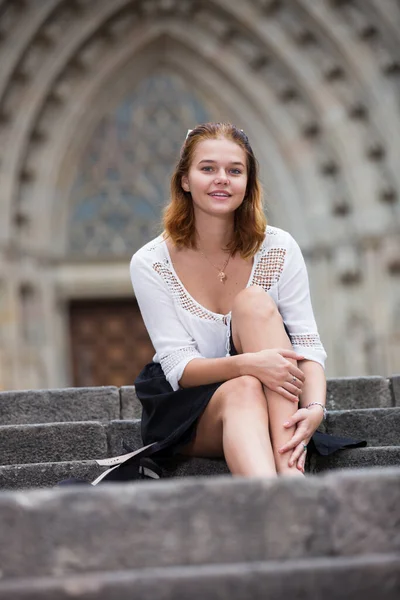 Jeune femme positive assise sur des escaliers en pierre — Photo