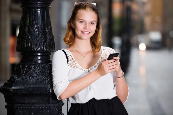 Portret uśmiechniętej dziewczyny korzystającej z telefonu komórkowego — Zdjęcie stockowe