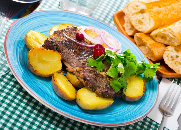 Beef steak with baked potatoes served at plate with greens Royalty Free Stock Photos