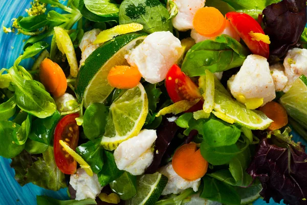 Ensalada sabrosa de merluza, limón, hojas de lechuga y zanahorias frescas —  Fotos de Stock