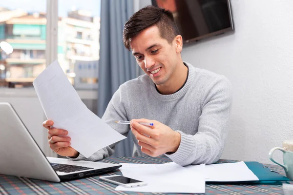 Homme souriant avec ordinateur portable analysant le budget domestique — Photo