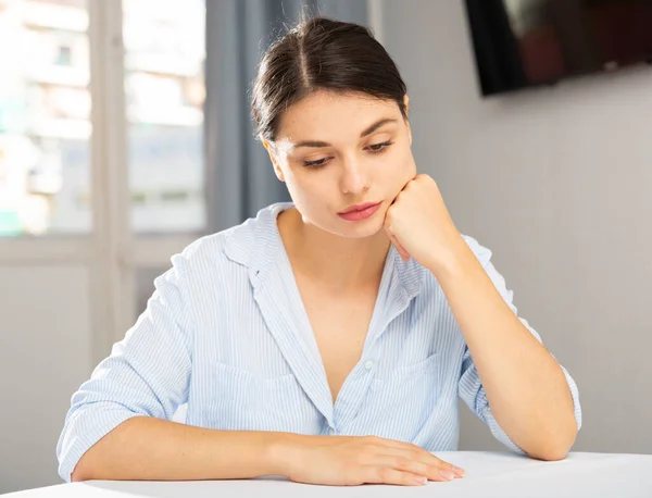 Porträt eines traurigen Mädchens, das zu Hause im Wohnzimmer sitzt — Stockfoto