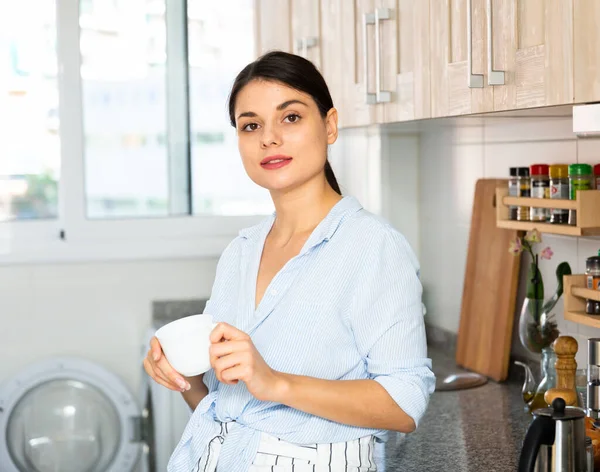 Женщина мечтает на кухне с чашкой кофе — стоковое фото