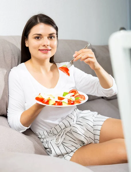 Kobieta je sałatkę na kanapie — Zdjęcie stockowe
