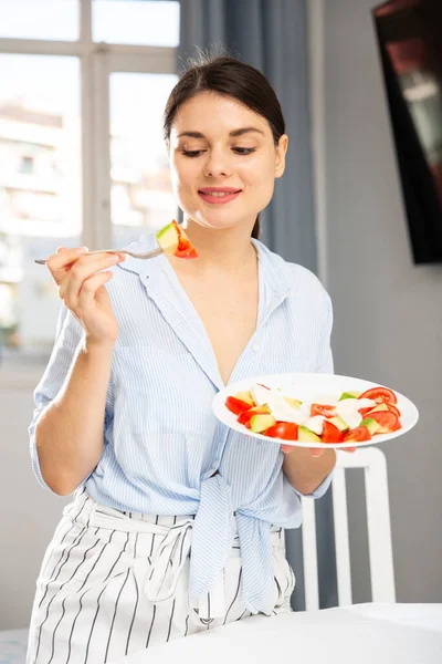 Menina agradável comer tomate e salada de abacate — Fotografia de Stock