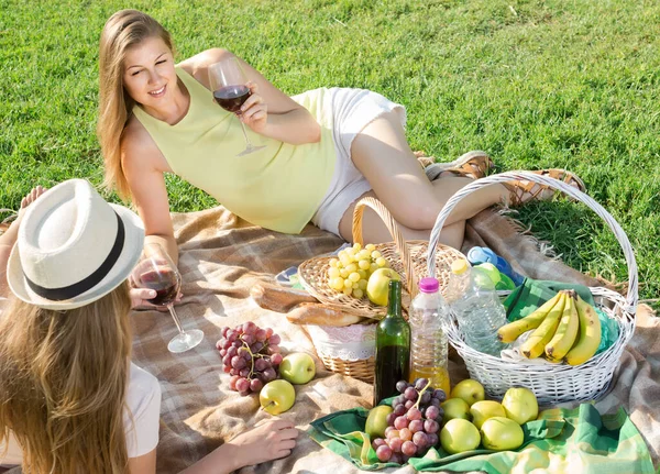 Atractiva mujer con amigo disfrutando de picnic al aire libre en el día de verano —  Fotos de Stock