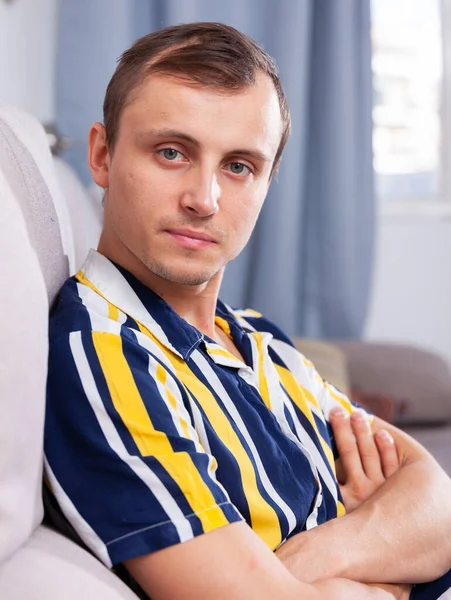 Attractive young man in a striped shirt at home — Stock Photo, Image