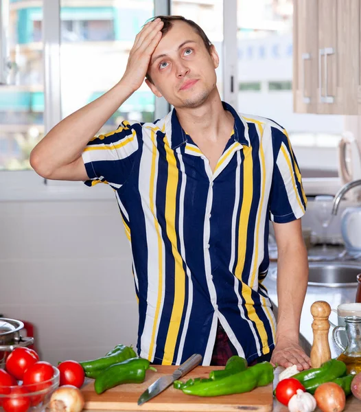 Jovem aprende a cozinhar na cozinha — Fotografia de Stock