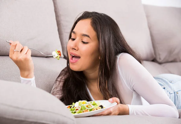 Jeune fille souriante manger une salade savoureuse — Photo