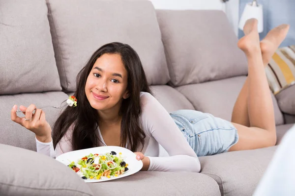 Молодая позитивная женщина ест салат — стоковое фото
