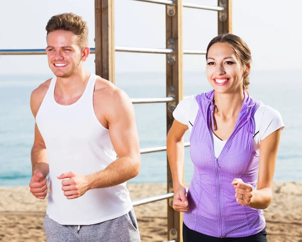 Junges Paar läuft am Strand — Stockfoto