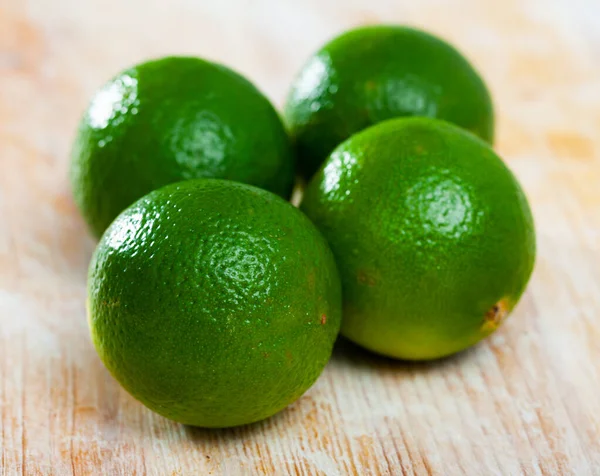 Imagen de limas frescas en la superficie de madera en la cocina casera —  Fotos de Stock