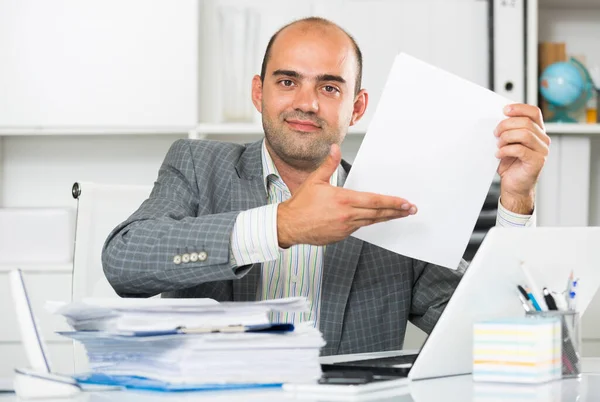 Бизнесмен в рубашке просматривает документы за столом — стоковое фото