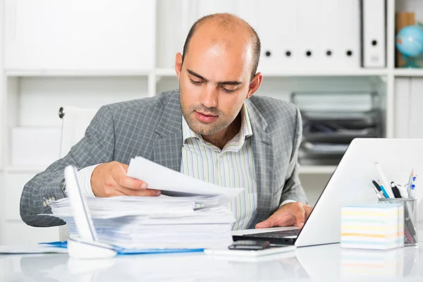 Homme d'affaires en chemise visualisant des documents à la table — Photo