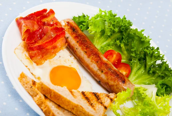 Τηγανητό αυγό, λουκάνικο, μπέικον και ψητό ψωμί — Φωτογραφία Αρχείου