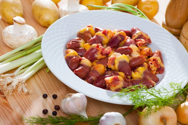 Raw freshness uncooked chicken hearts at plate on table — Stock Photo, Image