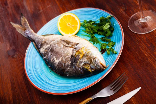 Baked in oven dorado fish with orange on plate — Stock Photo, Image