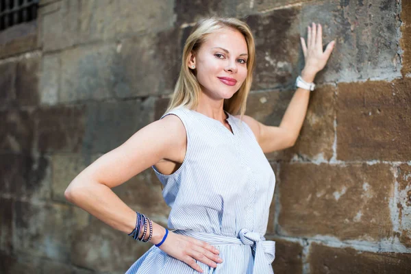 Femme souriante près du mur de pierre — Photo