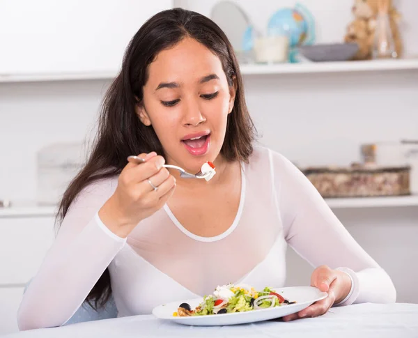 Positive young female eating salad — Stock Photo, Image