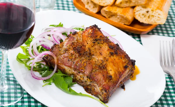 Baked pork ribs baked served at plate with salad from arugula — Stock Photo, Image