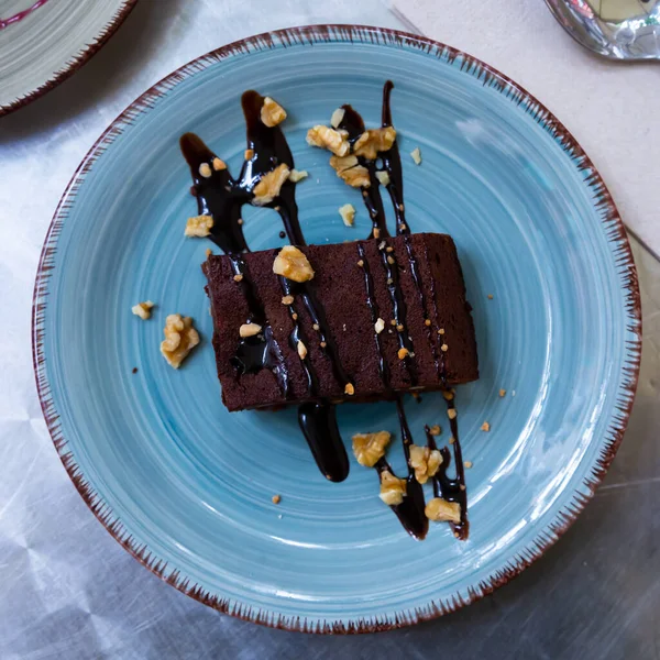 Stukje chocoladetaart met chocolademousse en nootjes als decoratie — Stockfoto