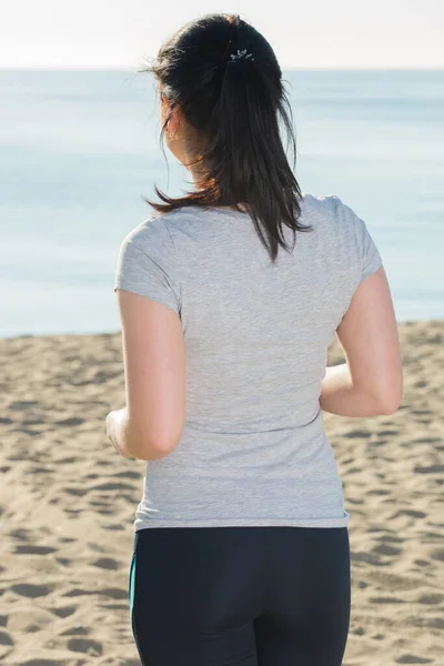 Energiska flicka kör på stranden — Stockfoto