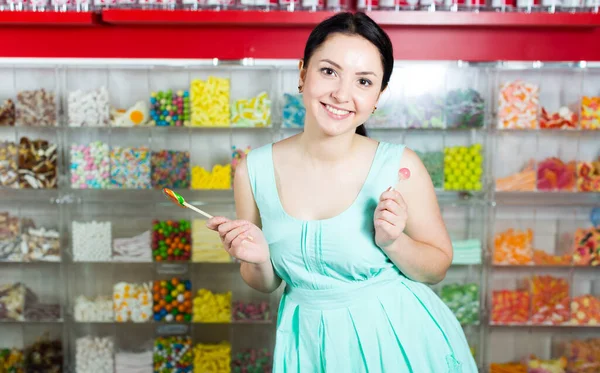 Gülümseyen kız markette lolipop emiyor. — Stok fotoğraf