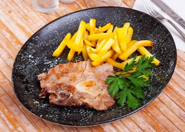 Côtelette de porc avec frites dans une assiette. — Photo