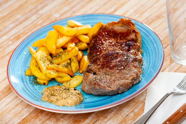 Pittig kalfsvlees entrecote met gebakken aardappelen en saus — Stockfoto