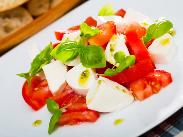 Dish of Italian cuisine caprese salad with fresh tomatoes and mozzarella cheese — Stock Photo, Image