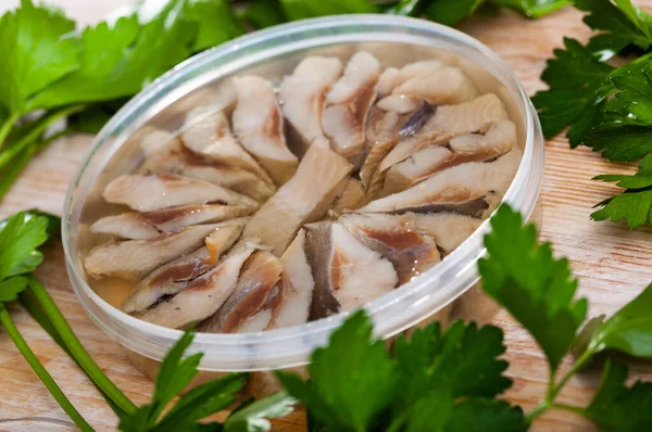 Pieces of pickled herring in oil in a plastic jar — Stock Photo, Image