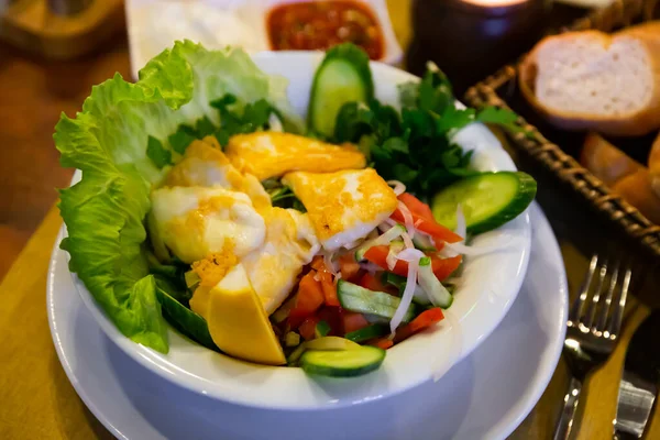Hellim salata, türkischer Salat mit Käse, Tomaten, Gurken, Zwiebeln und Zitrone im Restaurant — Stockfoto