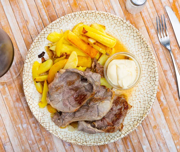 Roasted bone-in pork chop with crispy french fries — Stock Photo, Image