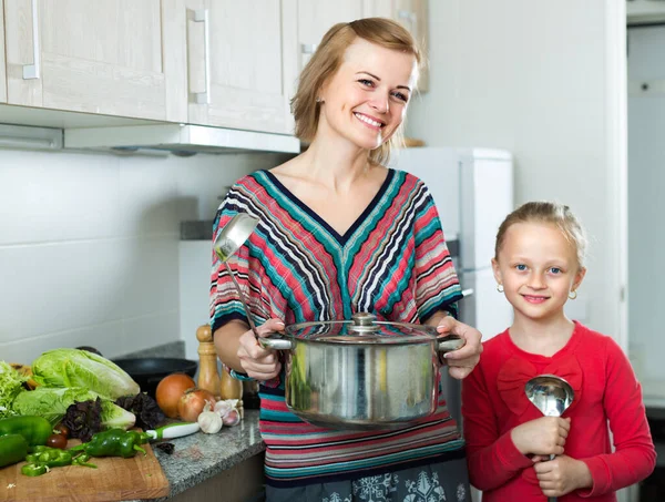 Klein meisje en moeder thuis keuken. — Stockfoto