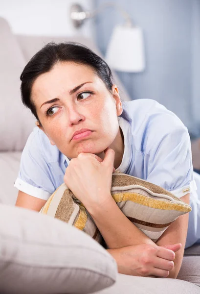 Jong verdrietig vrouw liggend op gezellige bank — Stockfoto