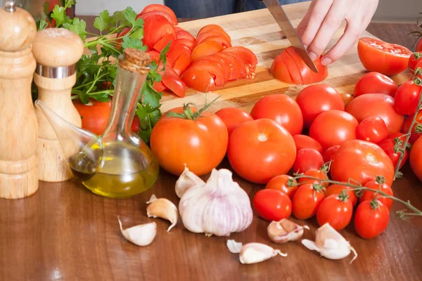 Hands  slicing tomatoes at table — Stock Photo, Image