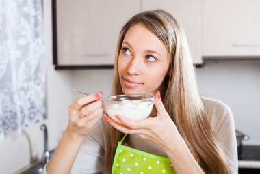 Smiling woman eating curd cheese clipart