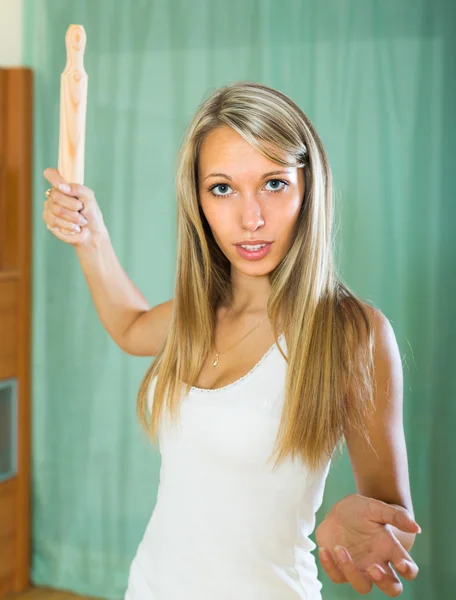 Furious girl swinging arm with rolling-pin — Stock Photo, Image