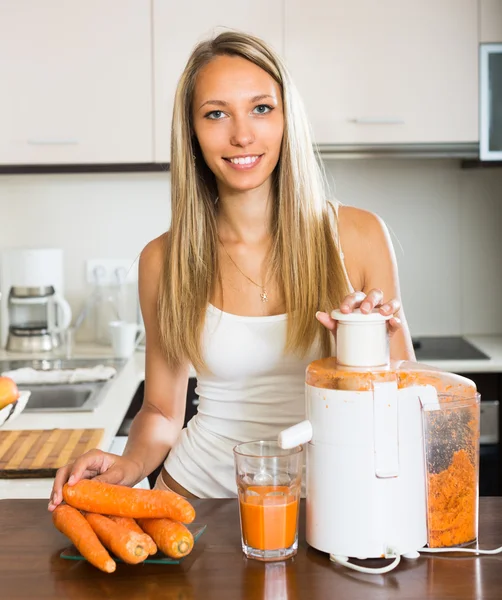 Chica haciendo jugo de zanahoria —  Fotos de Stock