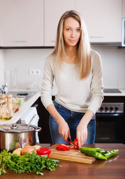 Blond kvinna skivning röd paprika — Stockfoto