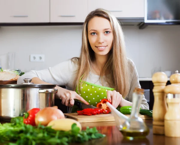 Usmívající se žena v domácnosti, vaření se zeleninou — Stock fotografie