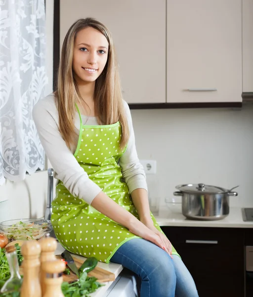 Chica sonriente en delantal en la cocina casera —  Fotos de Stock